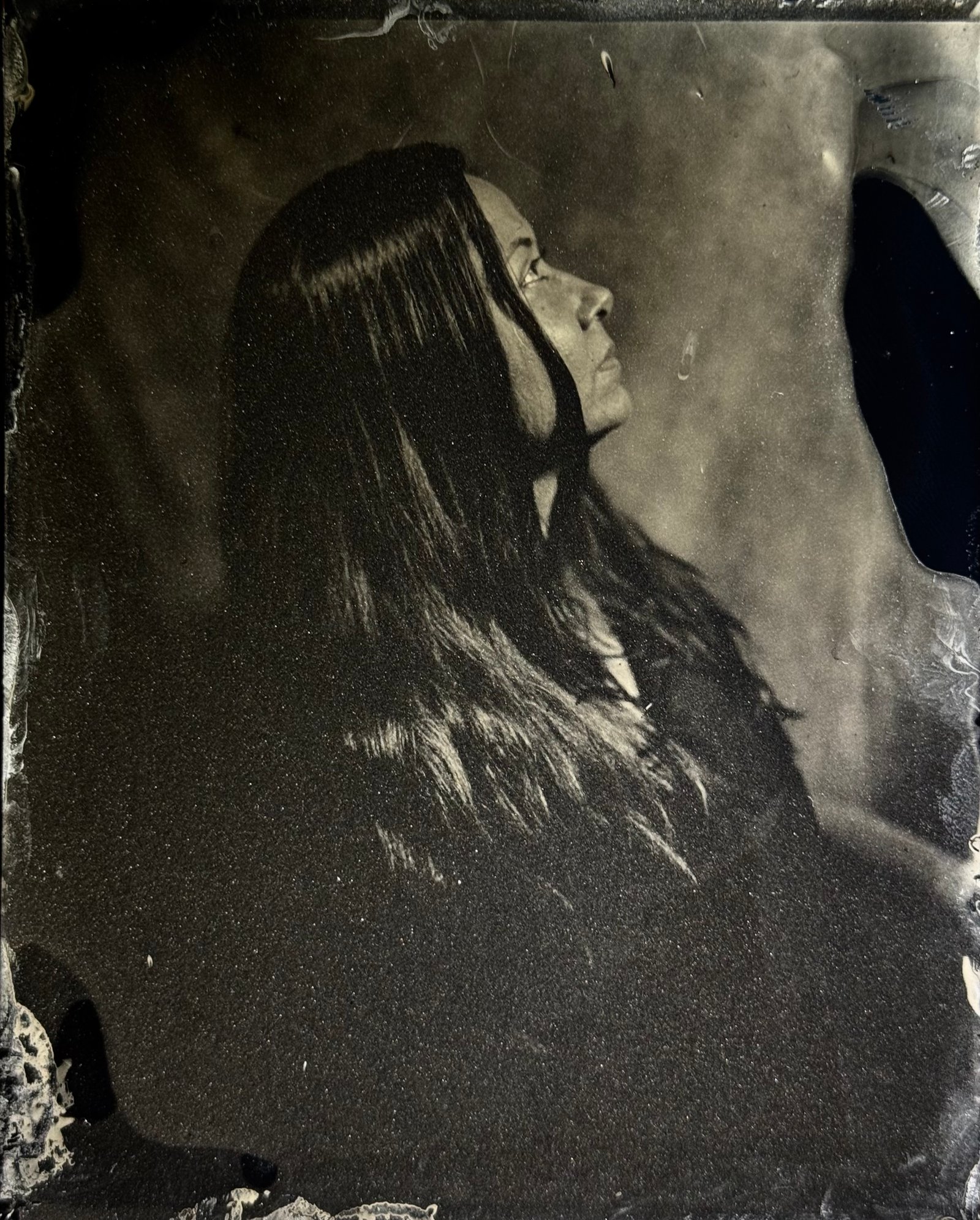 Hand holding a finished handmade tintype portrait plate